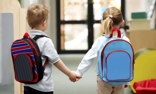 Two kids, a boy and a girl, holding hands